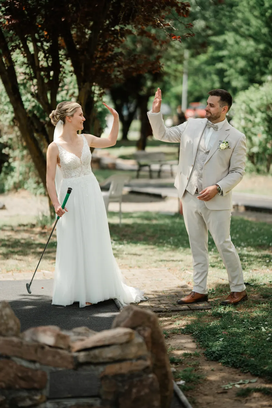 Braut und Bräutigam jubeln beim Minigolf