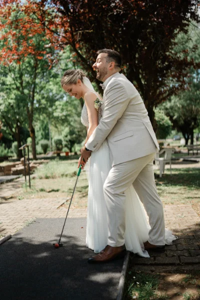 Braut und Bräutigam jubeln gemeinsam beim Minigolf
